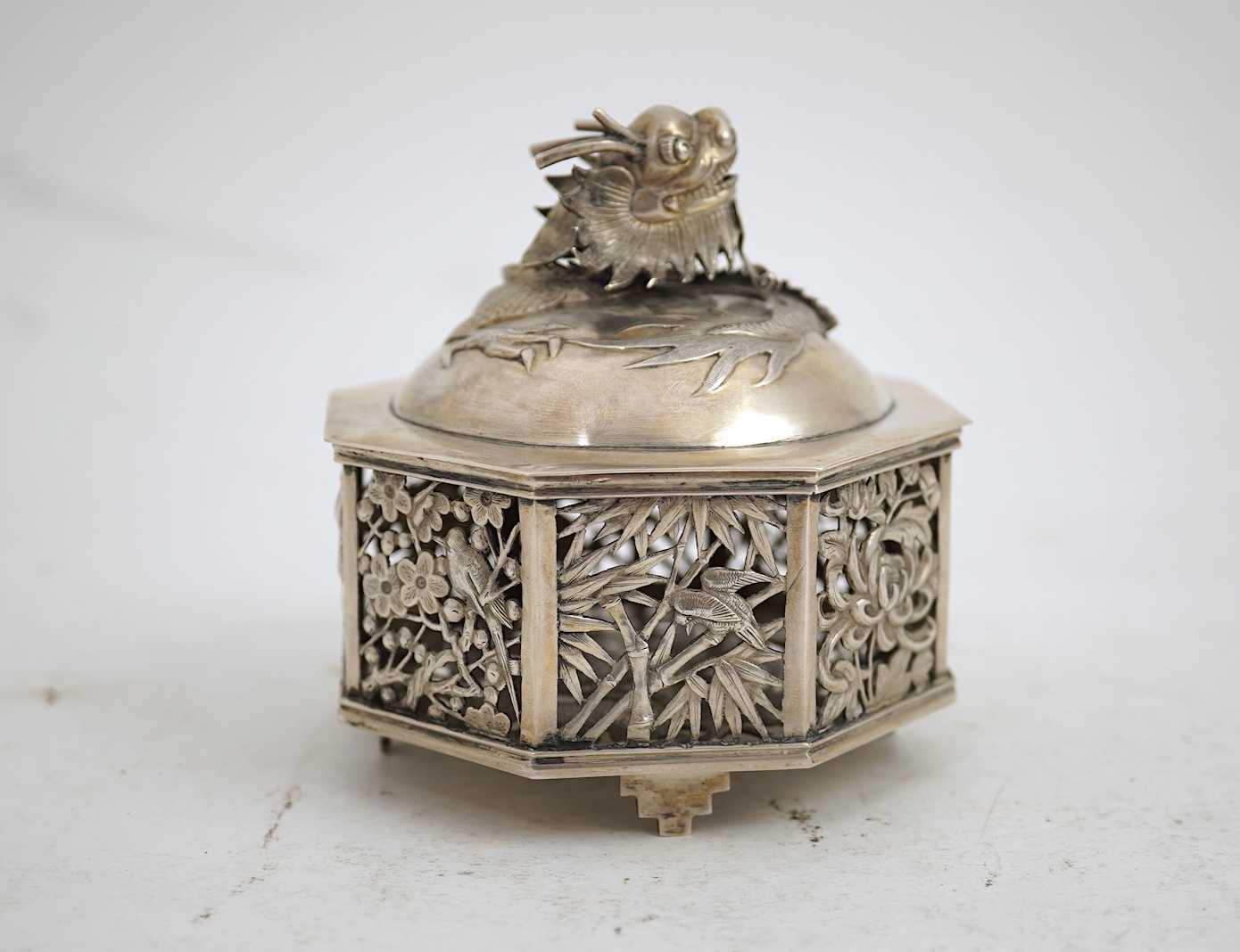A late 19th century Chinese Export pierced silver card case, maker KMS(Kwong Man Shing), decorated with dragons amid clouds, 10.4cm, together with a Chinese Export pierced silver octagonal box and cover, by Luen Wo?, cir